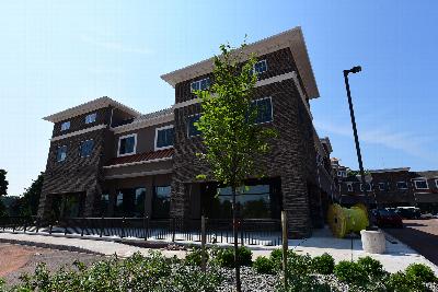 The Grove at Montgomery Exterior photo showing a brick exterior, a streetlight and a fence. Several bushes and trees highlight the landscape.