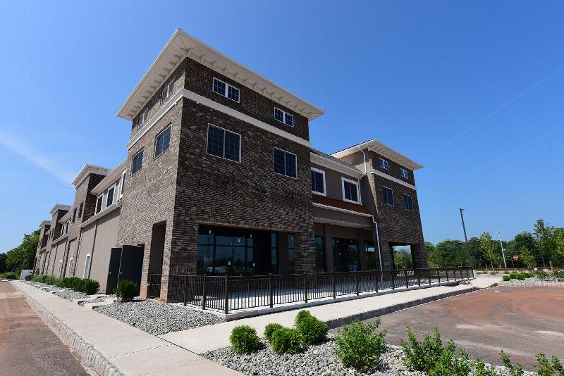 The Grove at Montgomery Exterior photo showing a brick exterior, a streetlight and a fence. Several bushes and trees highlight the landscape.