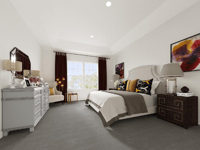 Suites at Sun Valley rendering of a Master Bedroom showing a queen sized bed with an end table and a large dresser. There is a sitting chairs and various wall decorations. Plush wall to wall carpeting covers the floors, and a large window allows for natural light.