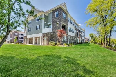 River Links exterior photo showing a typical 3 story apartment building at River Links. The exterior is finished with a mixture of brick and siding. Several balconies are shown as well as entrances. Lush grass and landscaping surround the area.