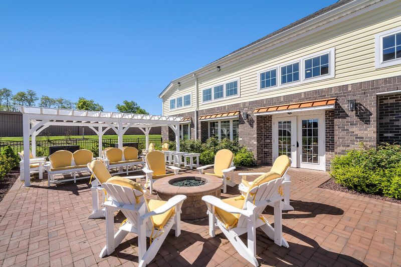 River Links exterior photo of the outdoor seating area of the clubhouse, showing a paver patio and several seating areas.