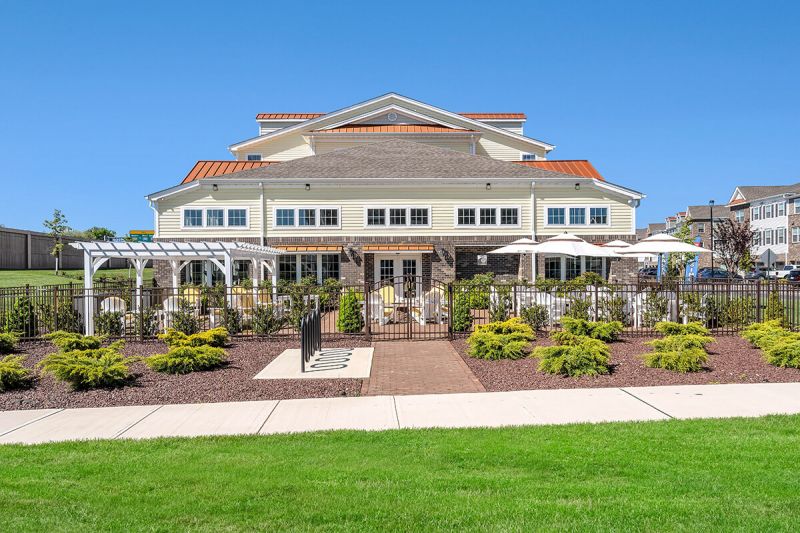River Links exterior photo of the outdoor seating area of the clubhouse, showing a paver patio and several seating areas.