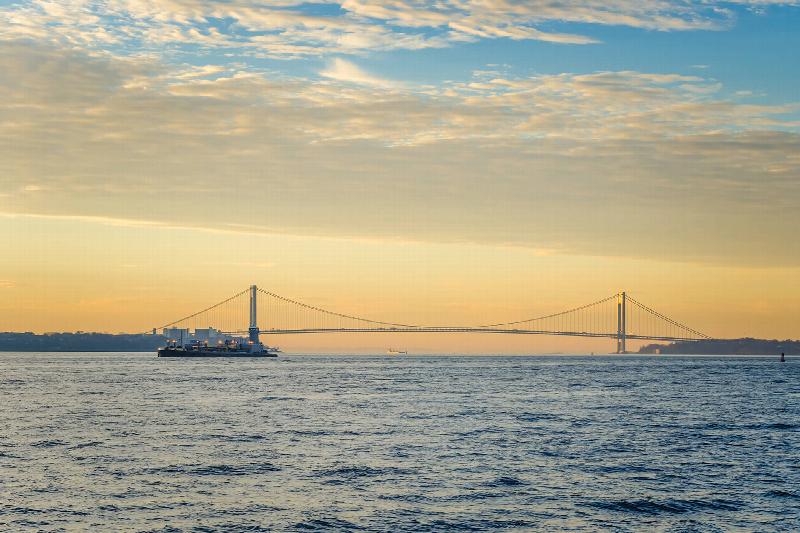Bayonne Bay exterior photo shows a sunset view of the Verazzano Bridge in the New York Bay.