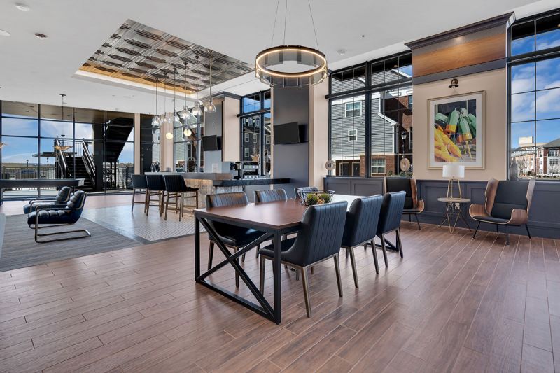 Interior photo of The Club at Bayonne Bay showing the lounge area featuring multiple seating areas in a large decorated room with large windows overlooking the community.