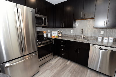 Sun Valley Plaza photo of kitchen showing dark cabinets, stainless steel appliances and granite countertops..