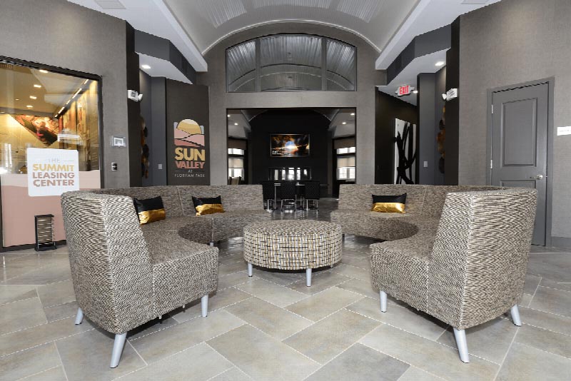 Photo of a seating area in the lobby of the Summit Club at Sun Valley. Entrance to the Leasing Center can be seen on the left.