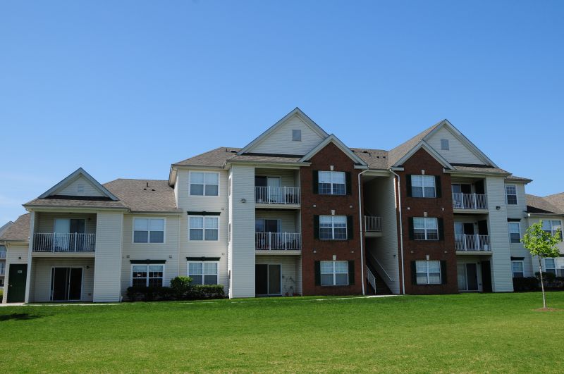 Meridian Square Exterior showing a 3 story apartment building with cream siding and lush landscaping.