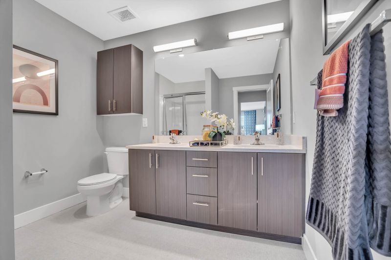 Interior photo of the Primary Bathroom off of the Primary Bedroom showing ceramic tile flooring. New cabinetry with Ceasar stone countertops and a toilet with medicine cabinet above.