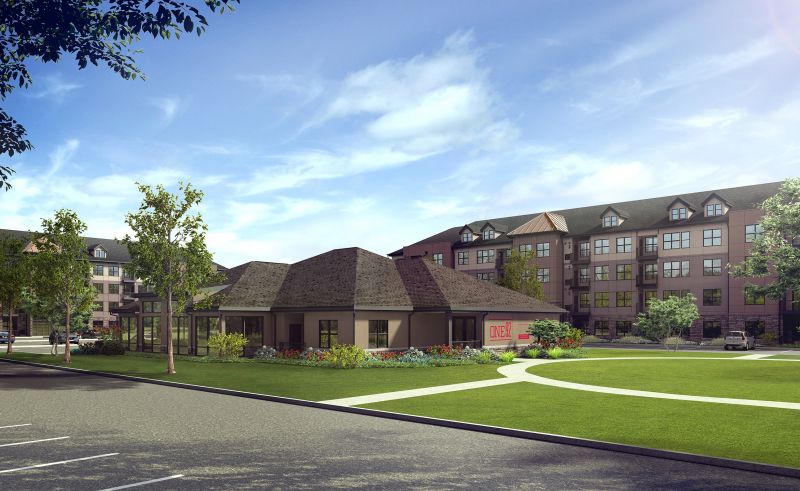 Grove Crossing Leasing Center & Clubhouse photo showing the Clubhouse and apartment buildings. The Clubhouse has a sign for One92 on the side of the building. There are several bushes and trees highlighting the landscape.