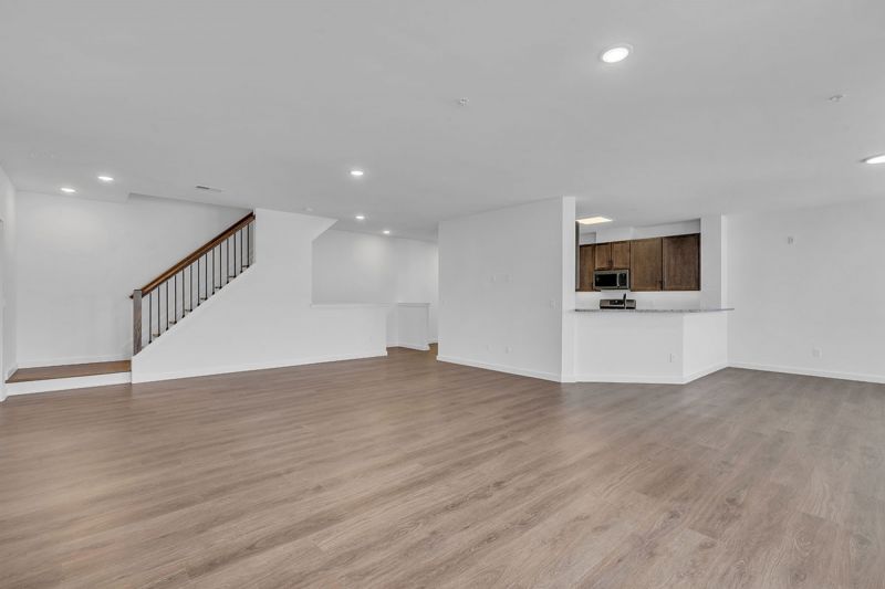 Interior photo of Amwell Terrace showing a large living area with luxury vinyl woodgrain flooring, and stairs leading up to the second level