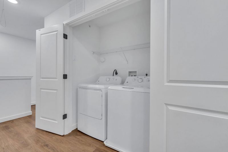 Interior photo of Amwell Terrace showing a closet containing a full size, side by side, washer and dryer.