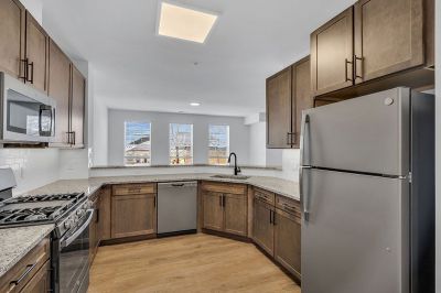Interior photo of Amwell Terrace showing the kitchen with luxury vinyl woodgrain flooring, new cabinets with granite countertops, and a stainless steel appliance package.