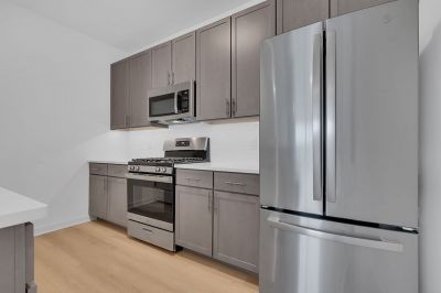 Photo of a kitchen at Rivendell Meadows showing stainless steel appliances, new kitchen cabinets, and a light colored wood grain luxury vinyl floor.