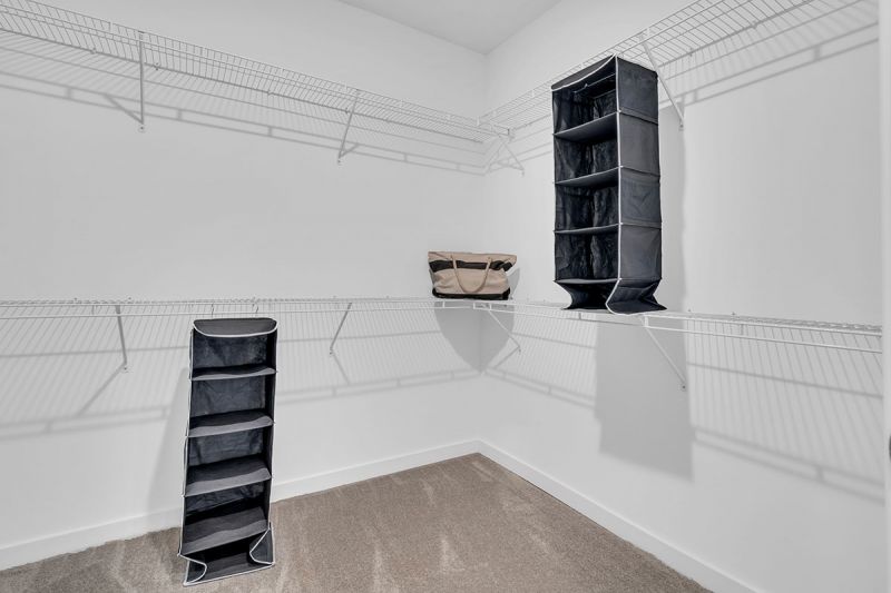 Interior photo of a Meadows at Mongomery apartment showing the walk in closet inside the primary bedroom with shelving for storage.