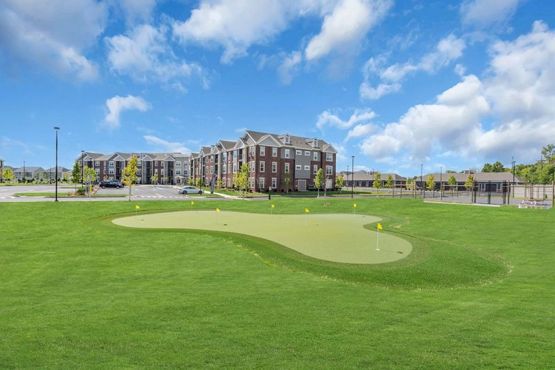 Exterior photo of Meadows at Montgomery showing the community golf putting green.