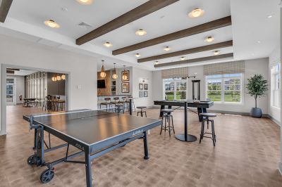 Photo of the community clubhouse showing a ping pong table, pool table and pub style seating