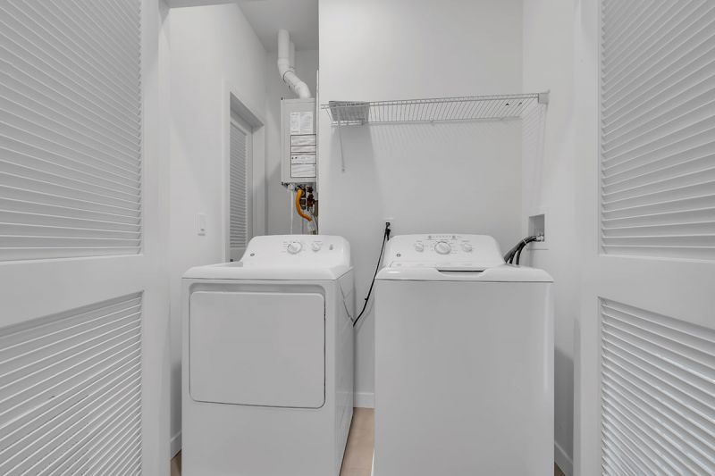 Photo of the full size washer and dryer available in some units at Edison Lights. There is a shelf for supplies above.