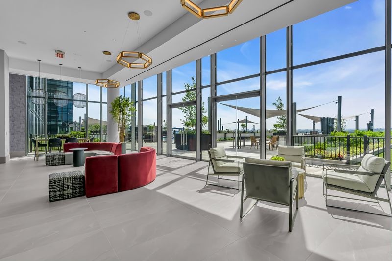 Interior photo of the lounge area on the 5th at RVR floor showing two large sectional couches and additional seating on opposite sides overlooking the community's exterior.