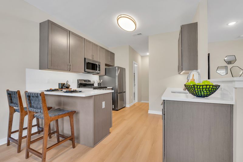 Interior photo of the Boulders at Beekman showing luxury vinyl flooring, gray cabinets, white granite countertops and stainless steel appliances.