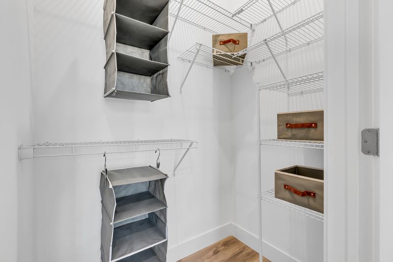 Interior photo of a typical walk in closet I an apartment at the Enclave at Woodhaven, showing multiple shelves and places to hang clothes.