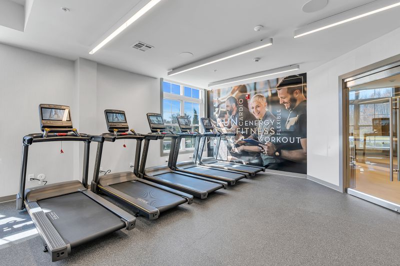 Interior photo of the gym at the Enclave at Woodhaven showing multiple treadmills.
