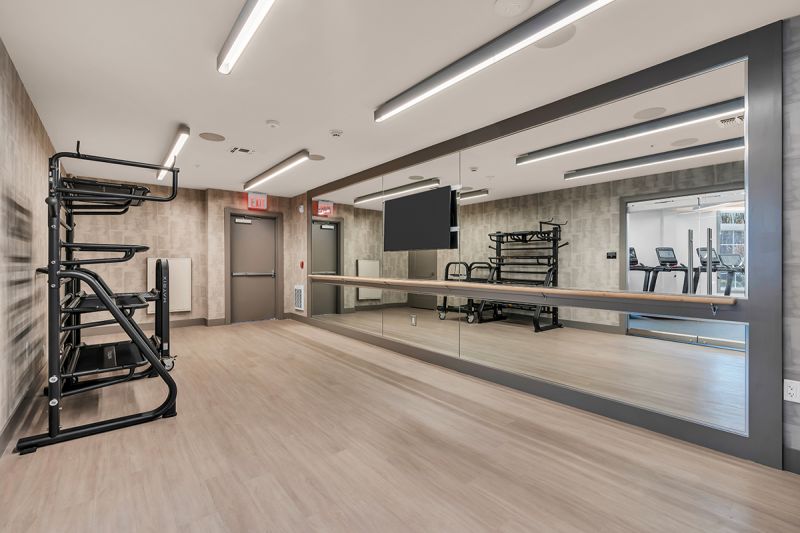 Interior photo of the gym at the Enclave at Woodhaven showing a room dedicated to yoga and stretching exercises.