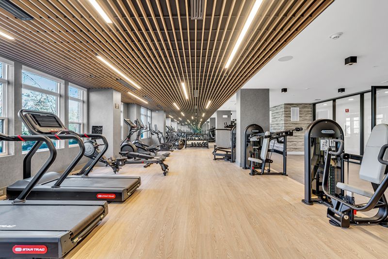 Interior photo of the community gym at Woodland Square with treadmills, and rowing machines including multiple strength and cardio exercise machines.