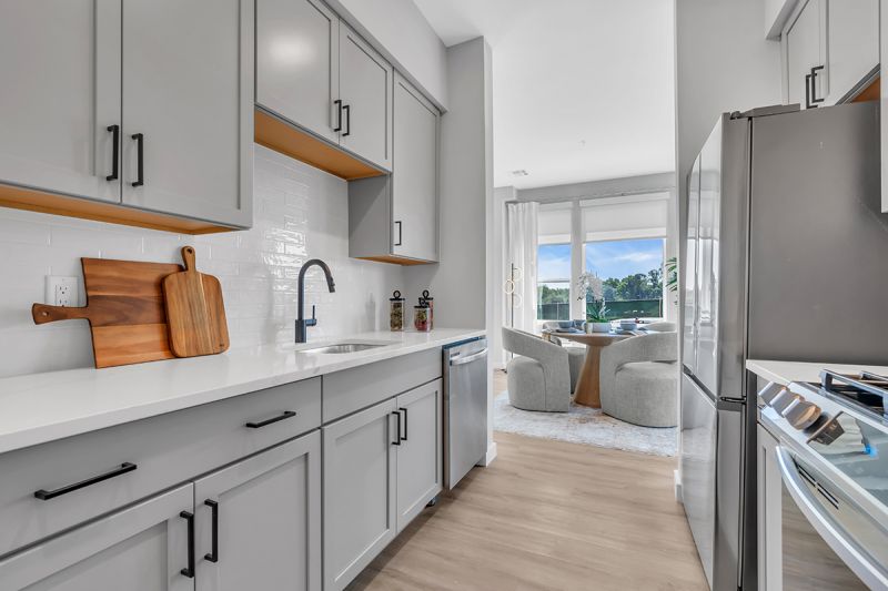 Interior photo of the dining room in Woodland Square featuring a circular table seating 4 people with large floor-to-ceiling windows overlooking the community.