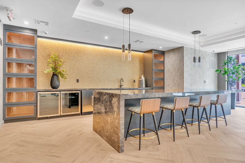 Interior photo of the community room at Woodland Square showing a professional demonstration kitchen with a large marble counter and bar-height seating.