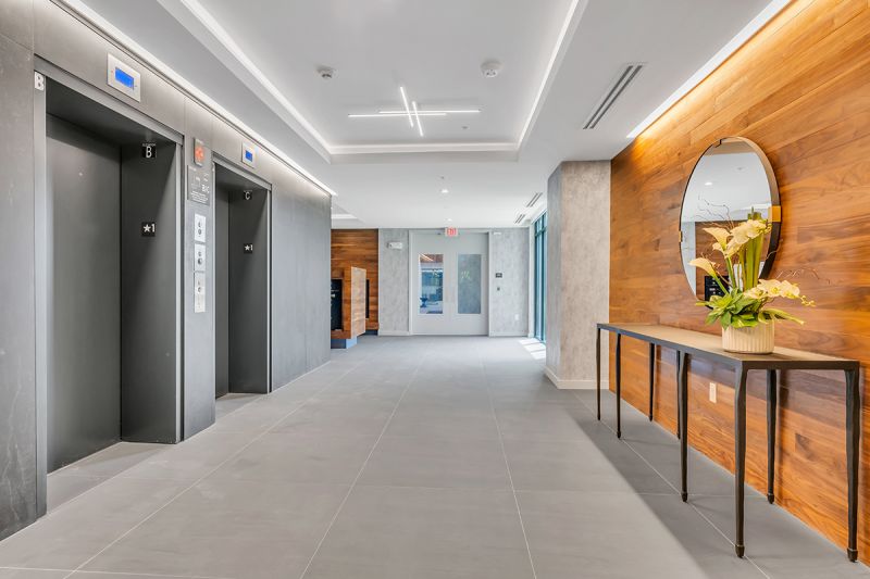 Interior photo of a long corridor at Woodland Square showing two elevators