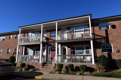 Exterior photo of Hilltop Manor showing a brick apartment building with brand new balconies.