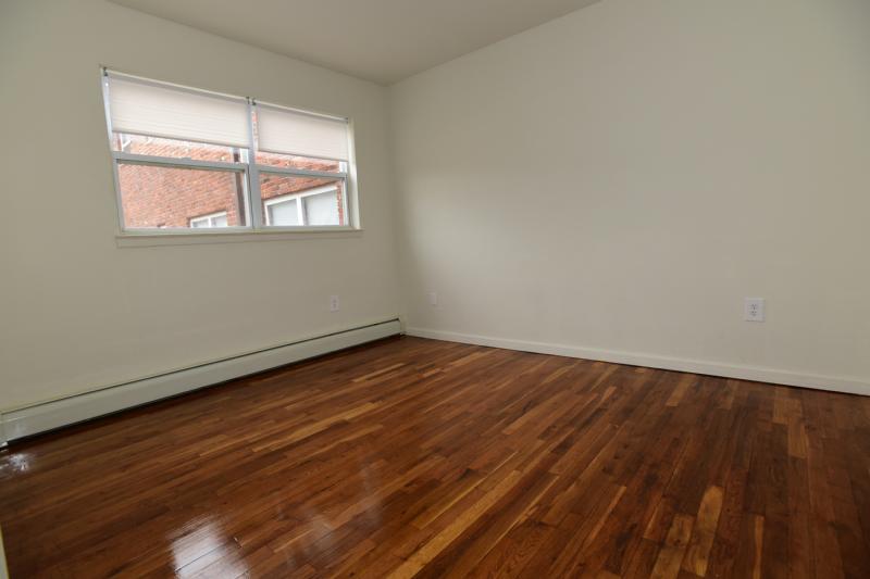 Hilltop Estates interior photo of bedroom showing hardwood floors and a large window to allow for natural light.