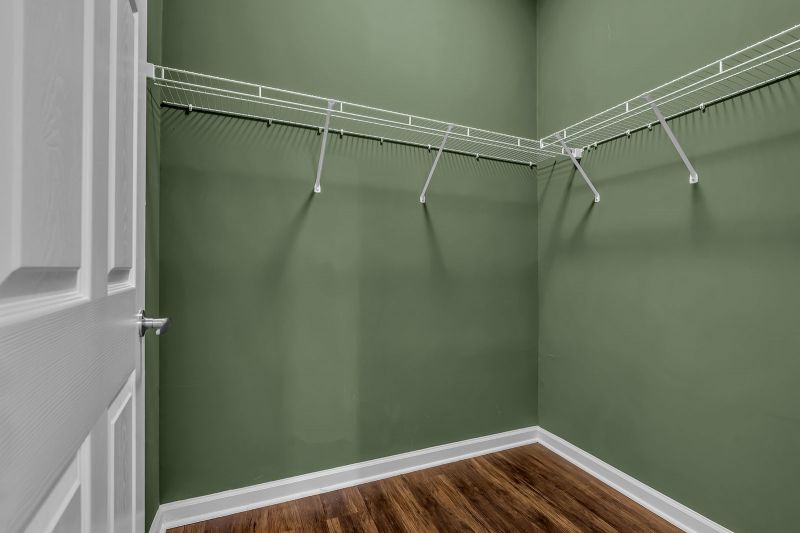 Interior photo of a model at Helix at Xchange featuring a walk-in closet with luxurious hardwood flooring. The space is equipped with wired racks along the walls for ample storage.