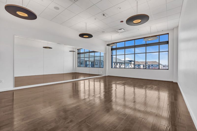 Interior photo of the yoga room at Xchange at Secaucus showing an open layout ideal for solo practice or guided sessions. The space is designed with neutral tones, soft lighting, and large mirrors to enhance focus, posture, and alignment.