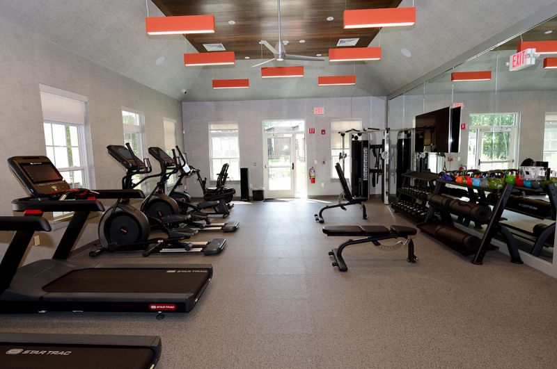 Blueberry and Edison Village Community Clubhouse interior image showing the community gym with multiple cardio equipment pieces and strength training stations. 