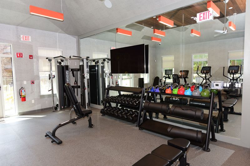 Blueberry and Edison Village Community Clubhouse interior image showing the community gym with multiple cardio equipment pieces and strength training stations. 