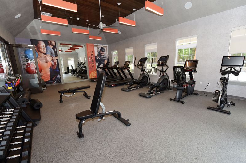 Blueberry and Edison Village Community Clubhouse interior image showing the community gym with multiple cardio equipment pieces and strength training stations. 