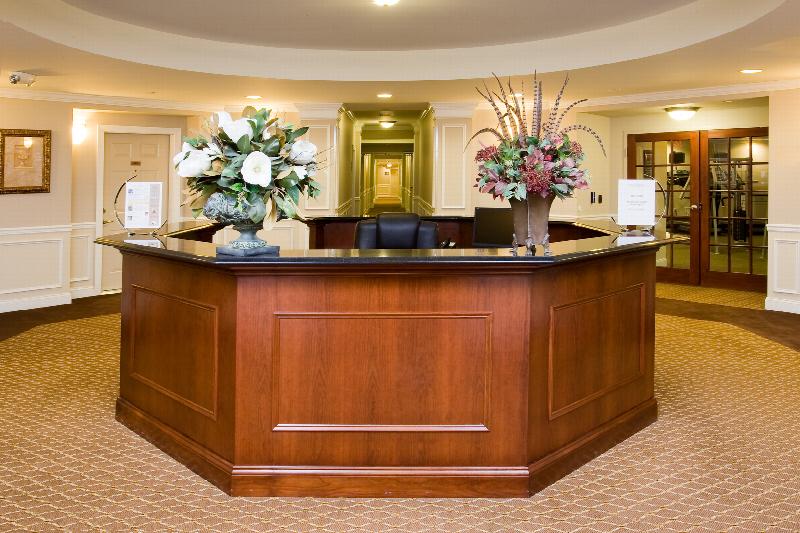Towne Centre at Englewood photo of one of the lobbies. At the center of the room is a large desk for greeting tenants. Two large flower displays are on the desk.