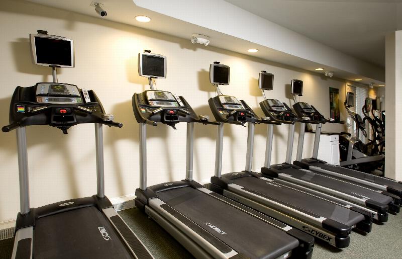 Towne Centre at Englewood photo of the Fitness Center shows several different types of exercise equipment including treadmills & ellipticals with video screens.