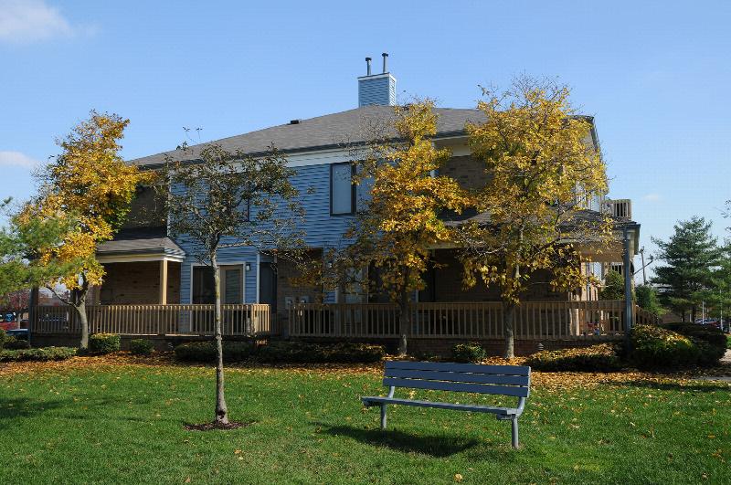 Peach Street Exterior photo showing a brick and vinyl exterior and several balconies. Several bushes and trees highlight the landscape.