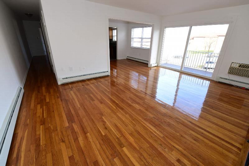 Delaware Heights living room showing hard wood floors and a large sliding door to balcony.