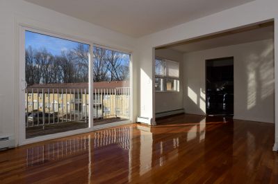 Delaware Heights living room showing hard wood floors and a large sliding door to balcony.