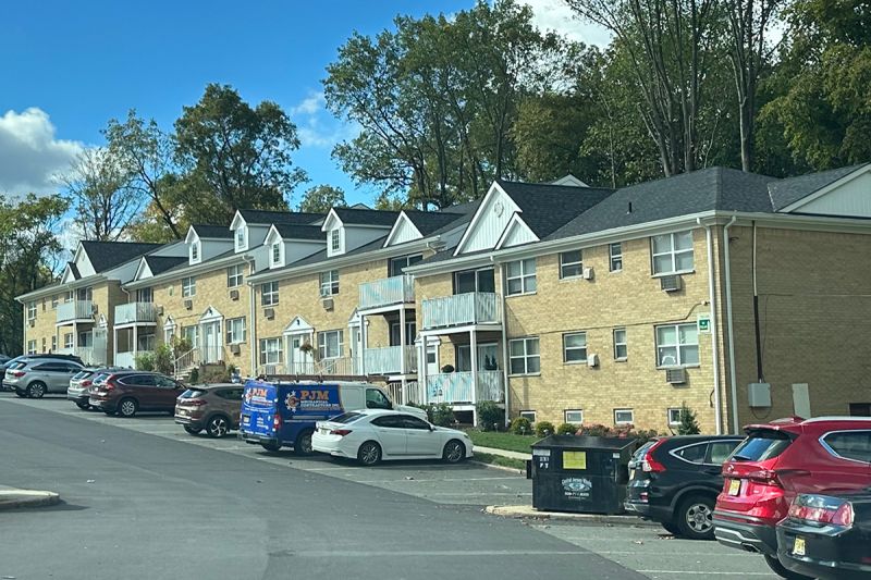 Exterior photo of Delaware Heights showing a 2 story brick building with balconies and a new roof. Landscaping in front of the buildings character