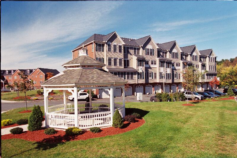 Sun Valley Plaza photo of a community gazebo on a lush green lawn, with apartment buildings located behind it.