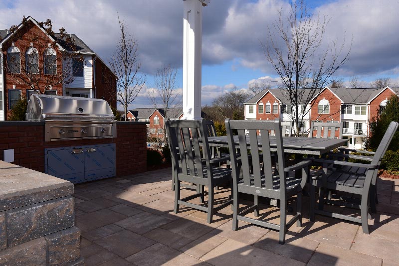 Exterior photo of the patio area at the Summit Club located at Sun Valley showing a patio table with chairs located next to a large grill.