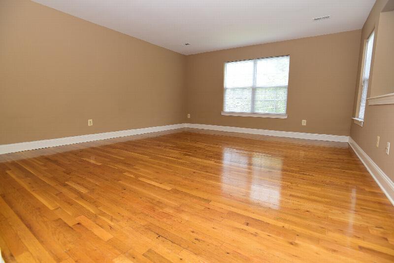 New Center Greens interior photo showing the bedroom with hardwood floors. There is a large window to allow natural light to enter the room.