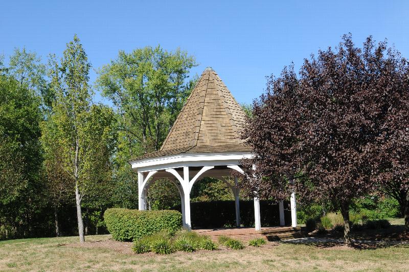 New Center Greens exterior photo showing the gazebo. Several bushes and trees highlight the landscape.