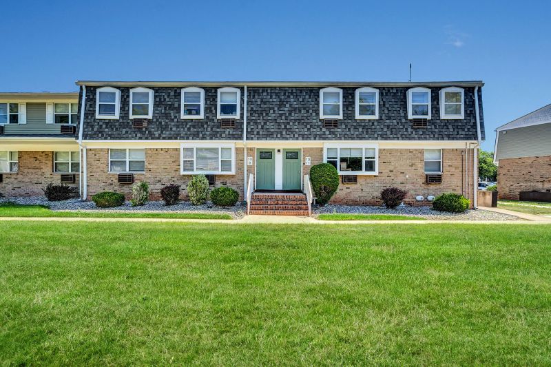 Exterior photo of Beekman Gardens in Hillsborough, showing a typical apartment building. Lush green landscaping and trees can be seen around the property.