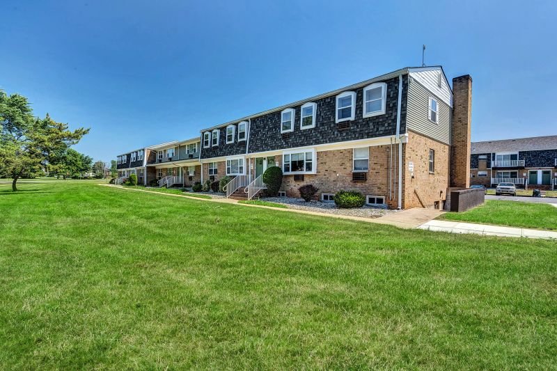 Exterior photo of Beekman Gardens in Hillsborough, showing a typical apartment building. Lush green landscaping and trees can be seen around the property.