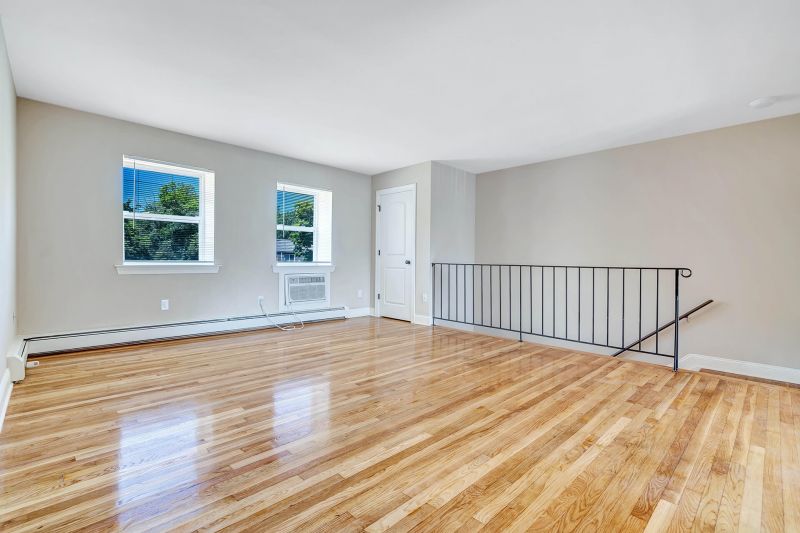 Interior photo of a refurbished apartment at Beekman Gardens in Hillsborough, NJ showing fresh paint and newly refinished floors. Stairs leading down to the apartment entry can be seen.